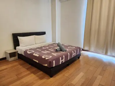 a bedroom with a bed with a brown comforter at Regalia Suites Best Couples Studio KLCC in Kuala Lumpur