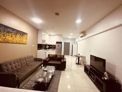 a living room with a couch and a table and a television at Mercu Summer Suites KL City Centre in Kuala Lumpur
