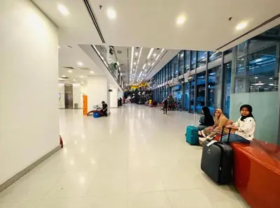 two women sitting on a bench in an airport with their luggage at Mercu Summer Suites KL City Centre in Kuala Lumpur