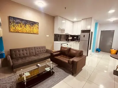 a living room with a couch and a table at Mercu Summer Suites KL City Centre in Kuala Lumpur