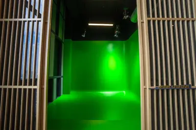 a green wall in the middle of a room at Societe by fafa in Kuala Lumpur