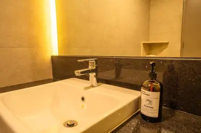a bottle of wine sitting on a bathroom sink at Societe by fafa in Kuala Lumpur
