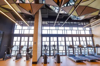 a gym with a row of treadmills and ellipticals at Societe by fafa in Kuala Lumpur