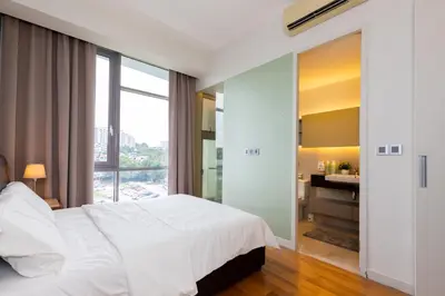 a bedroom with a white bed and a bathroom at SIgnature Residence - Desa Sri Hartamas - Studio in Kuala Lumpur