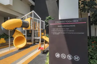 a sign in front of a building with yellow benches at Quill Residences by DX in Kuala Lumpur