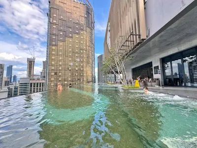 a swimming pool in a city with people in it at Axon Bukit Bintang Cozy 1BR Suite with KLCC View in Kuala Lumpur