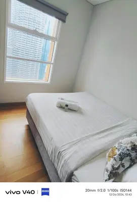 a bed in a room with a large window at Sky Suites KLCC by KD SKY Family Suites in Kuala Lumpur
