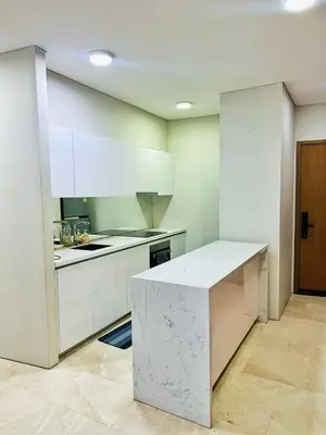 a kitchen with white cabinets and a counter in it at Sky Suites KLCC by KD SKY Family Suites in Kuala Lumpur