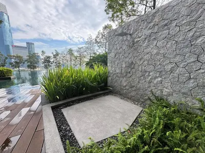 a stone wall with a walkway next to some plants at KL Cheras at The Continew 5 pax in Kuala Lumpur
