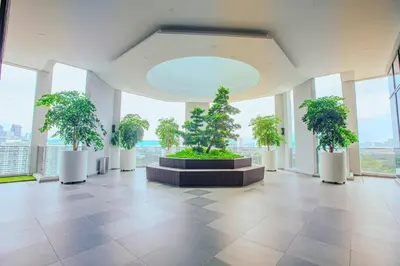 a large room with trees in a building with windows at The Atrium at Jalan Ampang by OKBnB - Cozy 2Bedroom ,3 mins to Foreign Embassies in Kuala Lumpur
