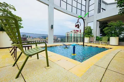 a chair sitting on top of a building with a pool at The Atrium at Jalan Ampang by OKBnB - Modern 2Bedroom, 10 mins to Pavilion KL in Kuala Lumpur