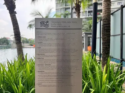 a sign in the grass next to a tree at Peaceful 3BR 2B with Pool 10pax Wangsa Maju near Wangsa Walk in Kuala Lumpur
