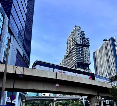 a train on a bridge in a city with buildings at NEW Bangsar Trade Centre KL Mid Valley LRT Bangsar in Kuala Lumpur