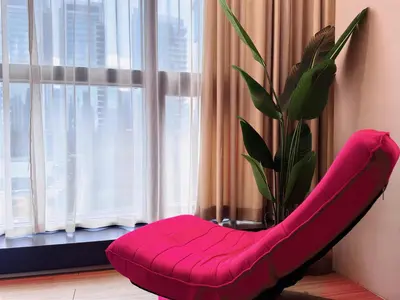 a red chair in front of a window with a plant at NEW Bangsar Trade Centre KL Mid Valley LRT Bangsar in Kuala Lumpur