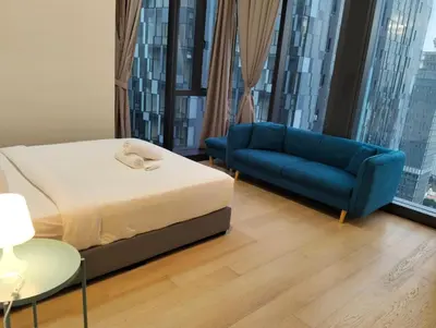 a bedroom with a bed and a blue couch at STAR Residences Popular By KLCC in Kuala Lumpur