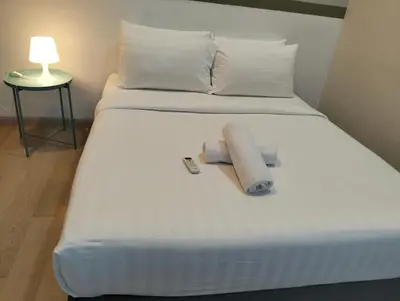 a white bed with two rolled up towels on it at STAR Residences Popular By KLCC in Kuala Lumpur