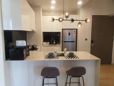 a kitchen with two bar stools and a counter top at STAR Residences Home Stay Near By KLCC in Kuala Lumpur