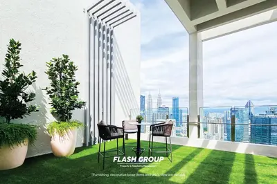 a balcony with a table and chairs on top of a building at Agile Bukit Bintang Premium Suites at KLCC in Kuala Lumpur