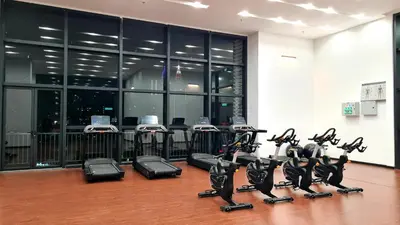a gym with a row of treadmills and exercise bikes at Chambers Suites KL By 969 in Kuala Lumpur