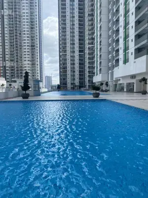 a large blue swimming pool in front of tall buildings at DUDUhomes in Kuala Lumpur