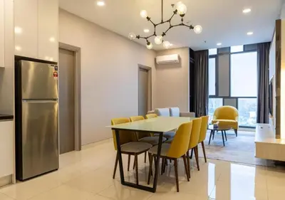 a kitchen and dining room with a table and yellow chairs at Hartamas Societe by MYAbnb in Kuala Lumpur