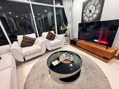 a living room with a large television and a clock at Vortex Suites Yonder Twin Tower in Kuala Lumpur