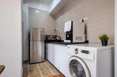 a kitchen with a washing machine and a refrigerator at Menara Arina Uniti 3km to KLCC 2BR 4Pax Mini Home in Kuala Lumpur