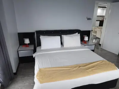 a bedroom with a large bed with white sheets and pillows at Eastern Suites Times Square KL in Kuala Lumpur