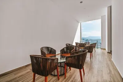 a group of chairs and tables in a room with a window at LUXE Infinitum KLCC by DX in Kuala Lumpur