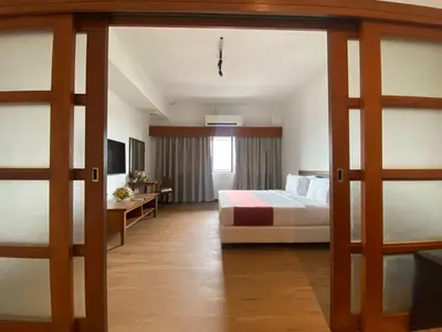 a bedroom with a bed and a desk and a window at 103 Hotel in Kuala Lumpur