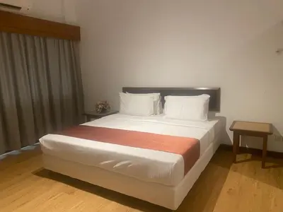 a bedroom with a large bed with two pillows at 103 Hotel in Kuala Lumpur