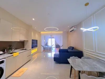 a kitchen and living room with a blue couch and a table at Lovely & Comfy Quill Residence, Near Monorail& Quill City Mall in Kuala Lumpur