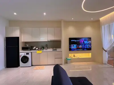 a kitchen with a refrigerator and a washer and dryer at Lovely & Comfy Quill Residence, Near Monorail& Quill City Mall in Kuala Lumpur
