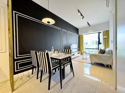 a dining room with a black wall and a table and chairs at Axon Bukit Bintang Lovely 1BR Suite with KL View in Kuala Lumpur