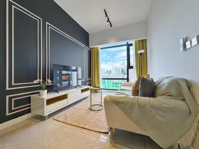 a living room with a couch and a television at Axon Bukit Bintang Lovely 1BR Suite with KL View in Kuala Lumpur