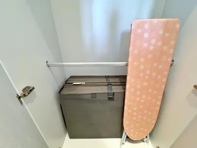 a small room with a suitcase and a pink curtain at Axon Bukit Bintang Lovely 1BR Suite with KL View in Kuala Lumpur
