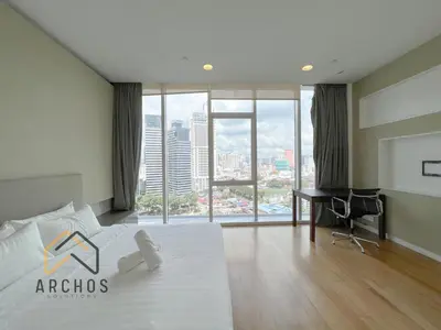 a bedroom with a bed with a desk and a large window at The Platinum KLCC by Archos in Kuala Lumpur