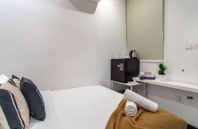 a white room with a bed with a mirror and a sink at Backpackers Studio at Neu Suites Ampang in Kuala Lumpur