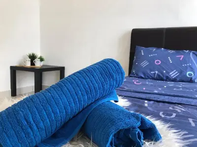 a blue blanket laying on the floor next to a bed at Ampang 4-6 pax in Ampang Point in Ampang