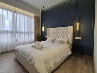a bedroom with a large white bed with a blue wall at Agile Pavillion TRX Luxury Suited Kuala Lumpur Good View in Kuala Lumpur