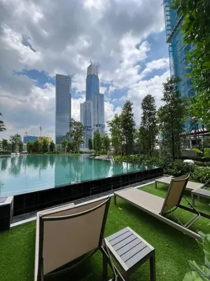a large pool of water with two chairs and a bench at Agile Pavillion TRX Luxury Suited Kuala Lumpur Good View in Kuala Lumpur