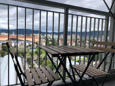 a wooden table and chair on a balcony with a view at Ampang 2 -3 pax Studio Ampang Point in Ampang