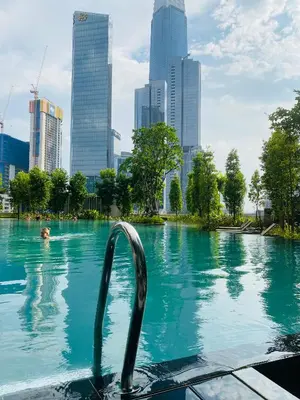 a person in a pool with a city in the background at Agile Sky Pavilion Residence KL TRX by Moonlight in Kuala Lumpur