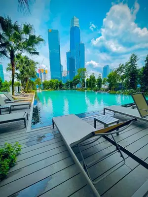 a swimming pool with lounge chairs and a city skyline at Agile Sky Pavilion Residence KL TRX by Moonlight in Kuala Lumpur