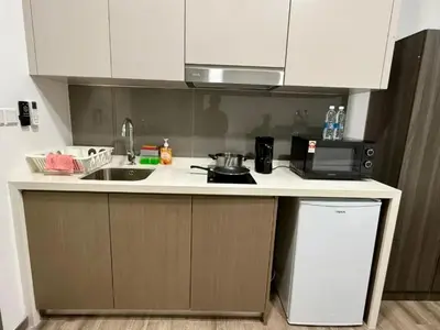 a small kitchen with a sink and a microwave at Agile Sky Pavilion Residence KL TRX by Moonlight in Kuala Lumpur