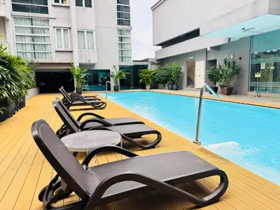 a row of lounge chairs next to a swimming pool at Soha Homestay in Kuala Lumpur
