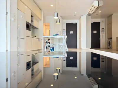 a kitchen with black and white cabinets and a reflective floor at XING LUN KLCC Platinum Suites in Kuala Lumpur