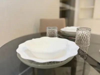 a table with a plate and two glasses on it at XING LUN KLCC Platinum Suites in Kuala Lumpur