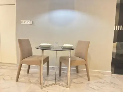 a table with two chairs and a table with plates on it at XING LUN KLCC Platinum Suites in Kuala Lumpur