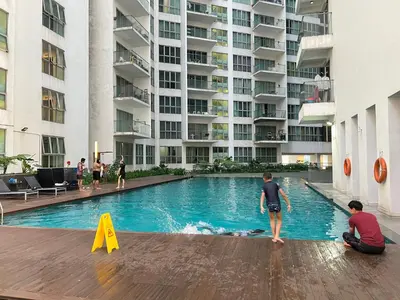 two boys playing in a swimming pool in a building at Empire Hostel Regalia in Kuala Lumpur